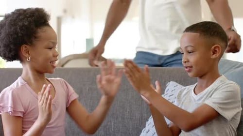 Children Play Clapping Game as Dad Watches