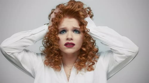 Portrait Of Exhausted Woman Holding Hands On Head In Studio. Worried Lady Having Stress. Closeup ...