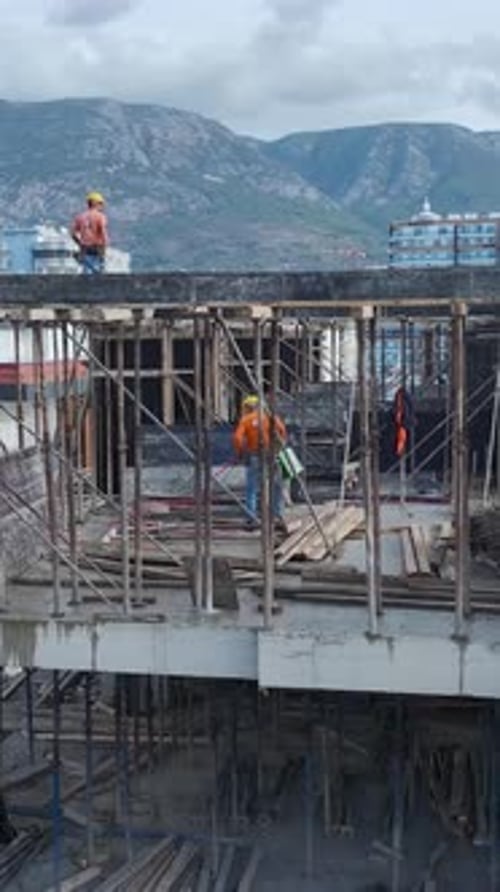 Actividad vertical de construcción en vídeo con trabajadores que preparan soportes y andamios para hormigón