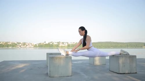 Athletic Woman Doing Splits and Stretching by Water