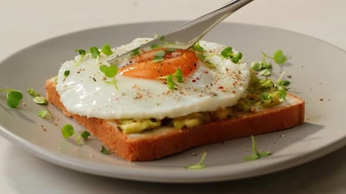 Avocado Toast with Fried Egg Sliced by Knife