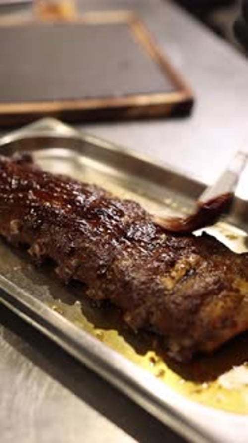 The cook prepares pork ribs, marinates and fries them.