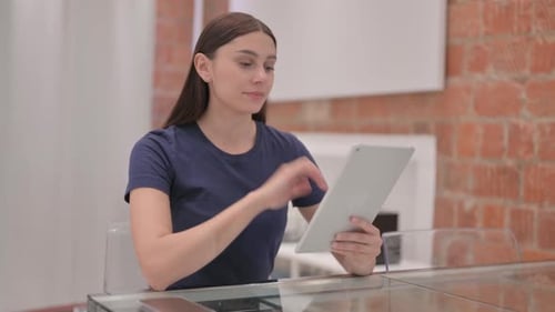Woman Using Tablet at Glass Table Indoors