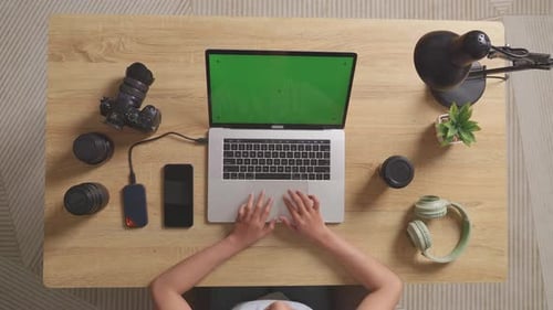 Top View Zoom In Shot Of A Woman Video Editor Using Green Screen Laptop Next To The Camera