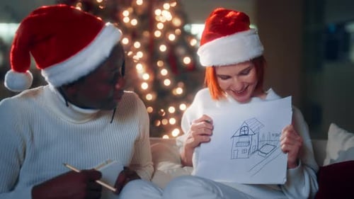 Couple Drawing Plans Together at Christmas in Cozy Home