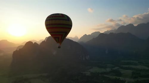 Episches Heißluftballon-Fliegen über dem Berg über dem Nebel bei Sonnenaufgang mit wunderschönem Himmel