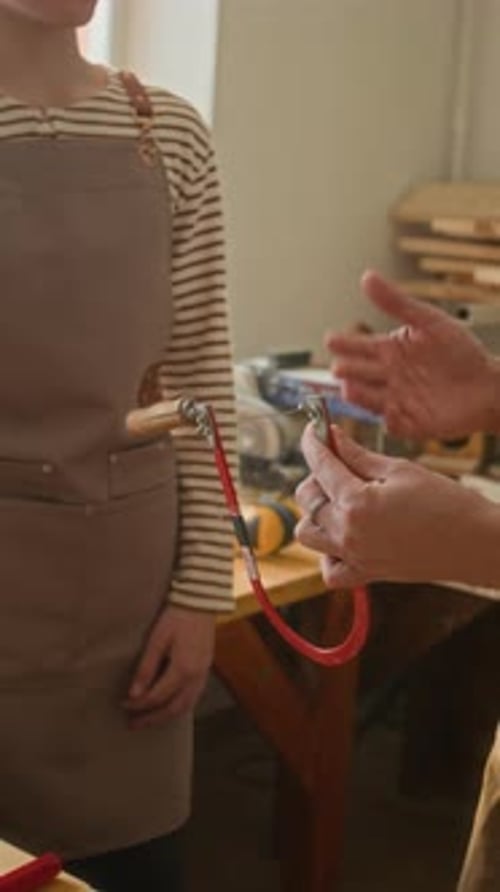 Vertical of Woodworking Instructor with Coping Saw Telling Boy about Its Blade