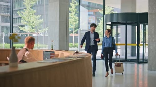 Business People Check Hotel on Trip Smiling Receptionist at Counter Greeting