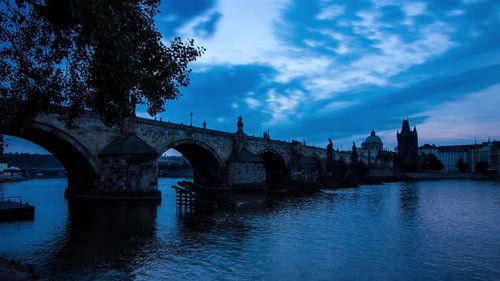 Blue morning timelapse of the Charles Bridge in Prague, Czech Republic next to the Vltava river with