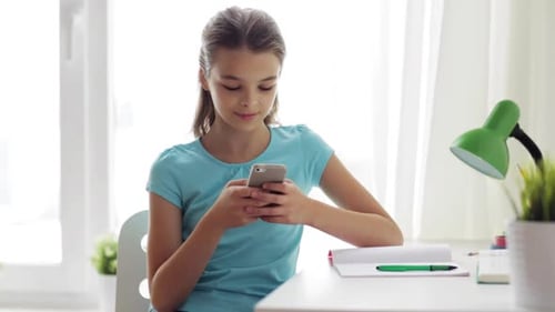 Teenage Girl Using Phone Indoors near Window