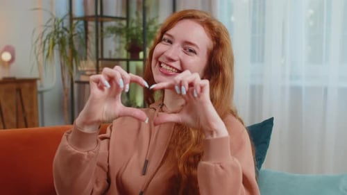 Woman Makes Heart Shape with Hands, Smiling