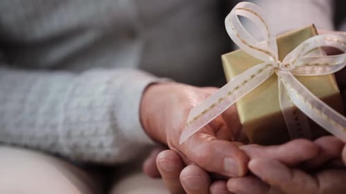 Senior Couple Sharing Gift, Close-Up Shot of Hands