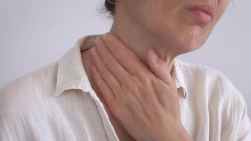 Frau bewegt schmerzenden Hals in Innenräumen
