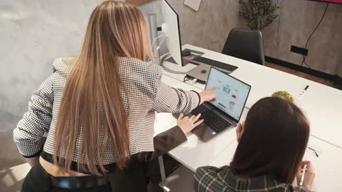 Three Women Collaborating on a Laptop in Office