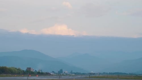 Flugzeug startet vom Flughafen mit Bergen im Hintergrund bei Sonnenuntergang Das Flugzeug startet vom
