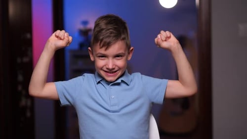 Smiling Boy Flexing His Bicep Muscles Indoors