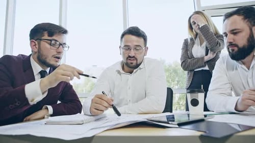 Team Discussing Documents Together at Bright Office Meeting