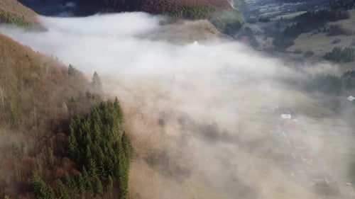 Aerial View of a Mountain Village in the Carpathians Morning Fog Covers Houses Fields and Forests in