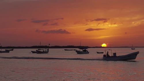 fishing boat passing by at sunset