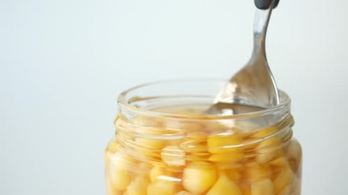 Spoon Pick Sweet Corns From a Container