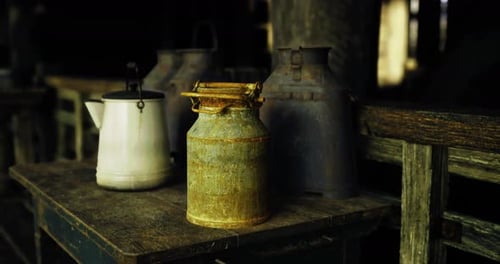 Cinematic Shot of Aged Rustic Milk Cans and Kettle