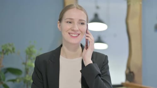 Woman in Business Suit Having Pleasant Phone Call