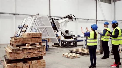 Gruppe von drei gemischtrassigen Arbeitern, die Schutzhelme und Warnwesten tragen, arbeiten mit virtuellen