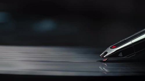 Extreme close-up of a record player's needle being placed on a track of the vinyl record before the