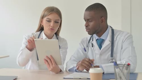Doctors Discussing Medical Data on Tablet