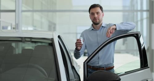 Happy Man Standing at Dealership Near New Car Handsome Young Male Choosing Transport to Buy Concept