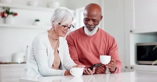 Senior Couple Using Phone in Modern Kitchen