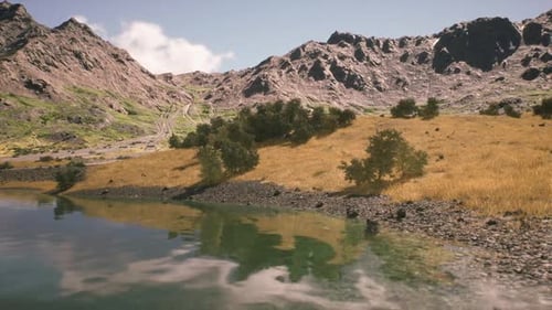 Vista panorâmica de um rio tranquilo refletindo montanhas em plena luz do dia