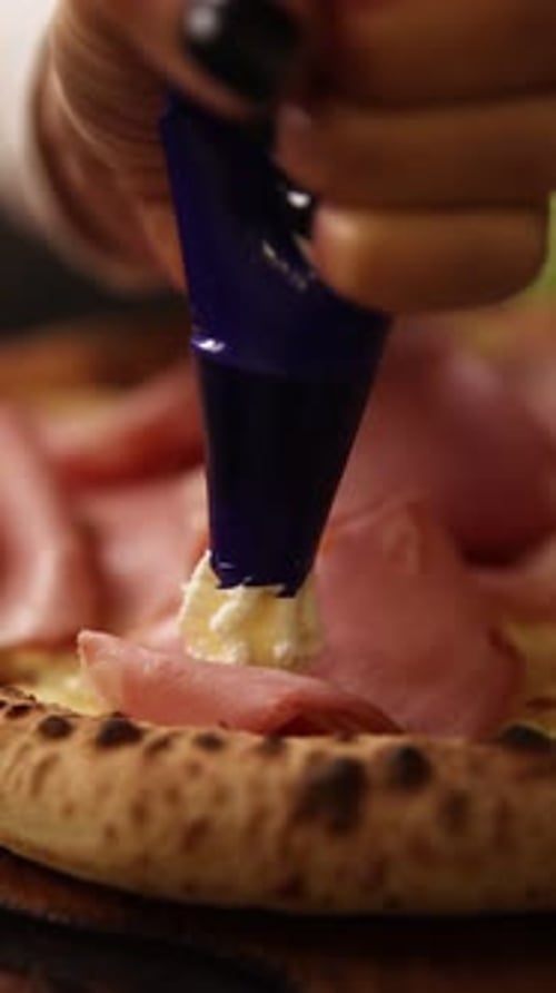 Adding Cream Cheese to Ham Pizza in Kitchen