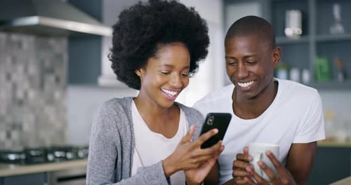 Happy Couple Enjoying Smartphone in Modern Kitchen