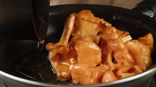 Chanterelles Being Poured and Stirred in Pan