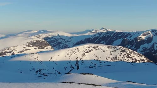 Drone shot from the arctic mountains top covered in snow