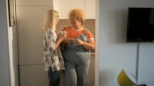 Two Women Chatting Together in Kitchen