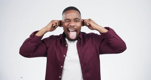 Funny, face and black man with tongue out in studio, ear pull and crazy expression on white