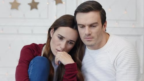 Sad couple thinking together in modern apartment living room portrait