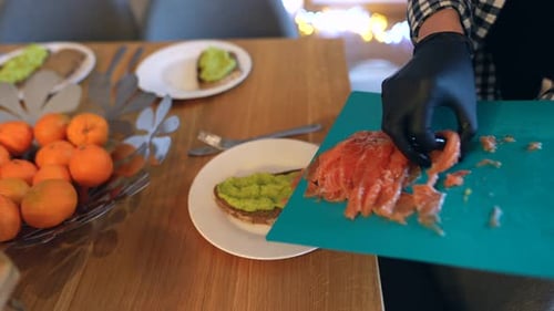 Person Prepares Salmon Avocado Sandwiches at Home