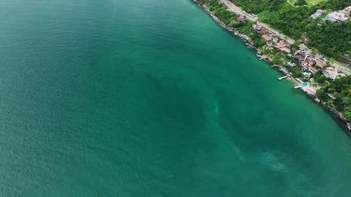 Aerial view of coastal town with greenery and ocean, Brazil.