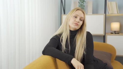 Thoughtful Woman Relaxing on Couch Indoors