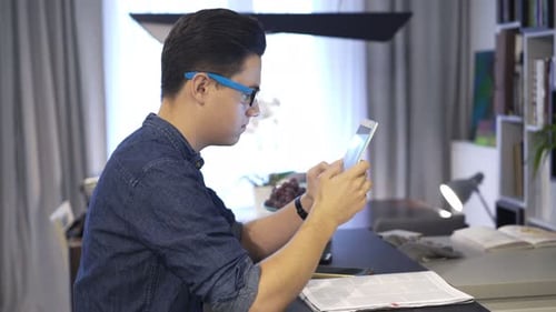 Man Uses Tablet at Desk in Modern Home