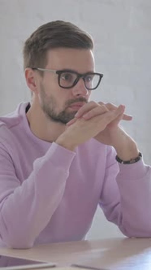 Young Man Thinking While Sitting in Office, Vertical Video