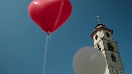Church tower with heart shaped balloons wedding day