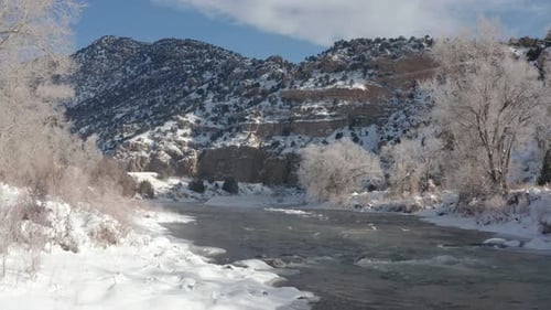 Snowy Mountain River with ice flow and fog
