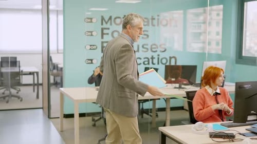 Boss Delivering Work Folders to His Employees in a Office
