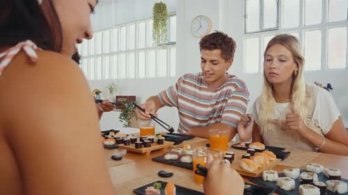 Group of friends eating sushi together at home.