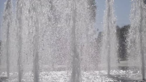 Powerful jet plumes make sparkling cascading display in water fountain SLOW TILT UP