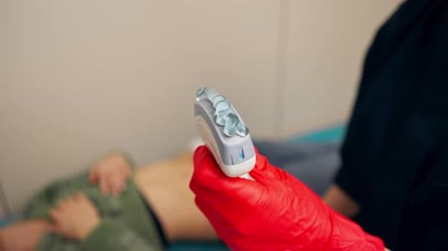 Dans un cabinet gynécologique d'une clinique, un médecin effectue une échographie des petits organes d'un patient.